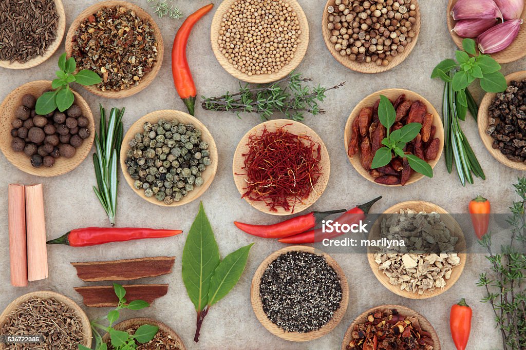 Herb and Spice Selection Herb and spice selection in wooden bowls and loose over grunge paper background. 2015 Stock Photo