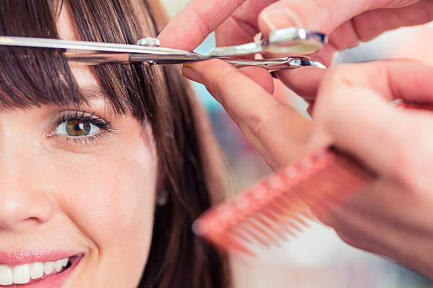 Hairdresser cutting woman bangs hair in shop Hairdresser cutting woman bangs hair in shop bangs stock pictures, royalty-free photos & images