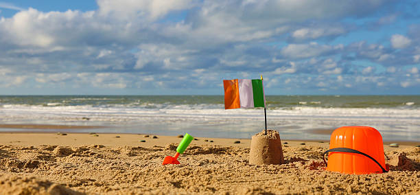 istock Beach, sea with bucket spade, sandcastle and Irish flag 536724401