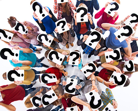Above view of large group of people holding question marks.