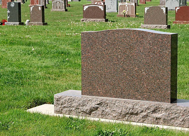 istock Large granite tombstone in a grassy cemetery 536747470