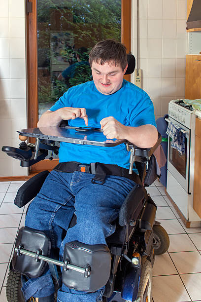 istock Spastic young man in wheelchair, dialing a phone number 536750065