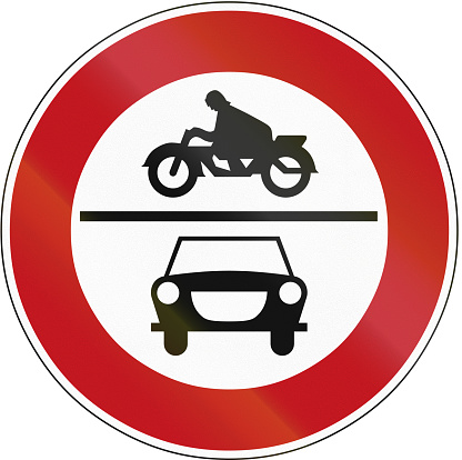 Old design (1970) of a German traffic sign prohibiting thoroughfare of cars and motorcycles.