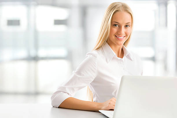 Free Stock Photo of A young blonde woman working on her laptop ...