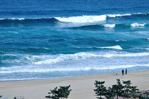 Big Waves rolling into shore and two fishing man