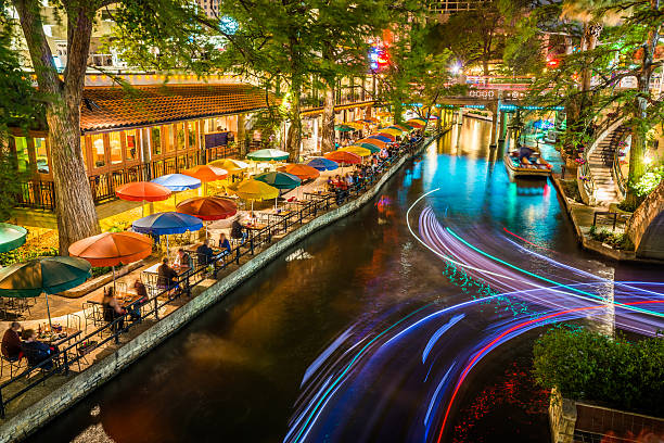 riverwalk a san antonio, texas, panoramico fiume canale turismo ombrelloni notte - entertainment center immagine foto e immagini stock