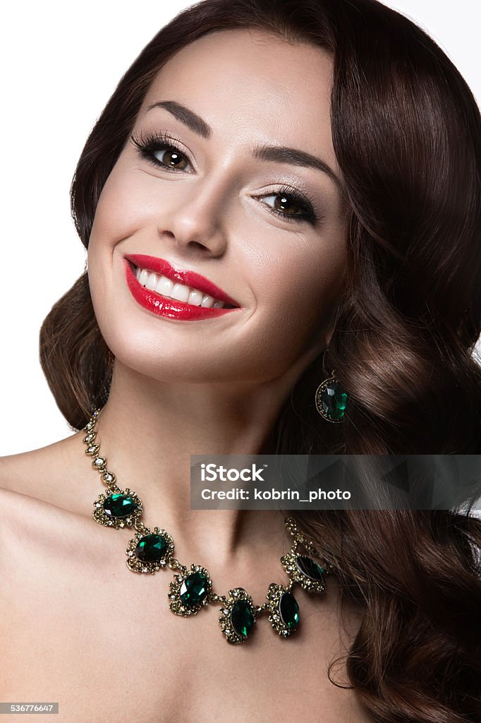 Beautiful woman with evening make-up, red lips and curls.  Beautiful woman with evening make-up, red lips and curls. Beauty face. Picture taken in the studio on a white background. 2015 Stock Photo