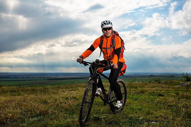 istock Young man cycling on a rural road through green meadow 536786710