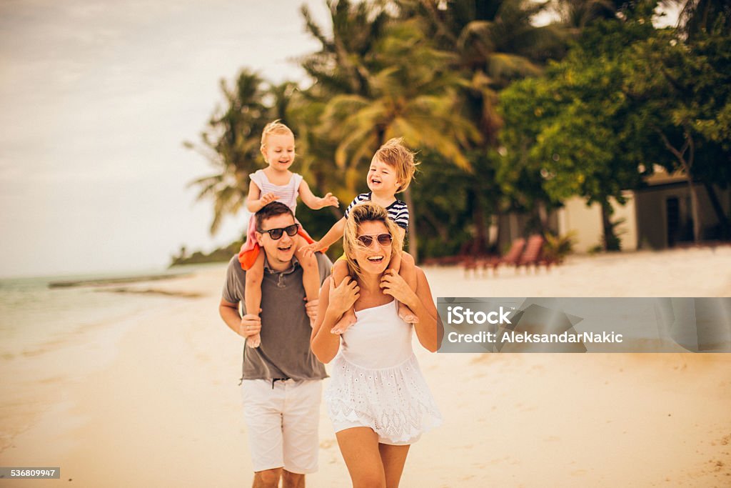 Playing on the beach Photo of a young family playing by the sea on one of the most beautiful Maldivian islands in the Indian Ocean 2015 Stock Photo