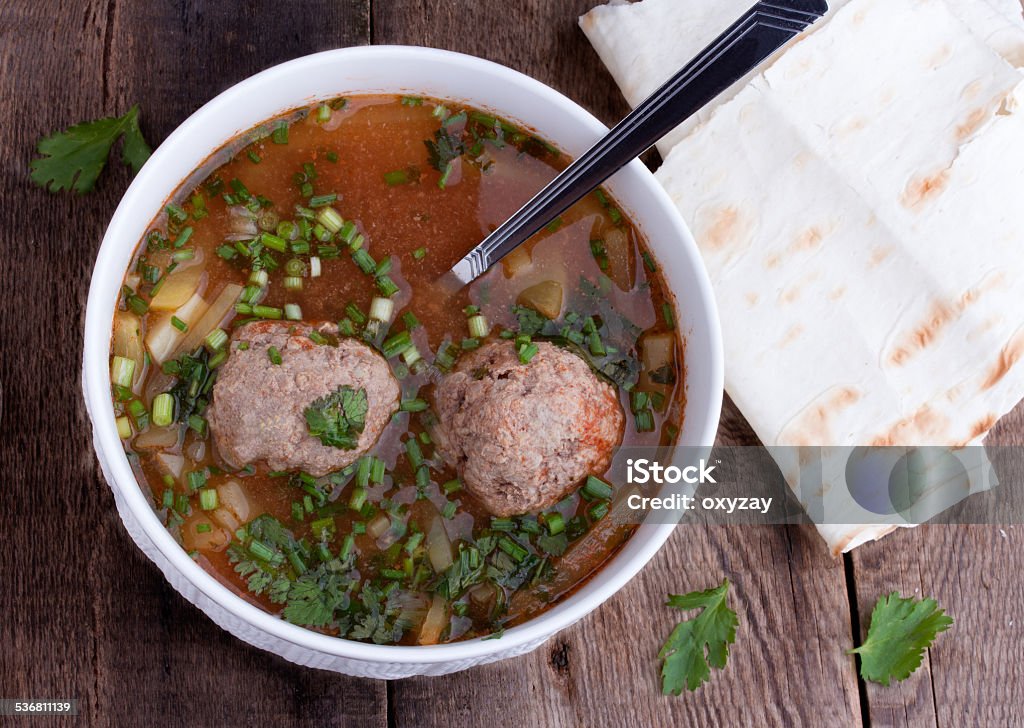 Tomato soup with meatballs Tomato soup with meatballs in white bowl. Traditional armenian soup called kololik. Wooden background. Meatball Stock Photo