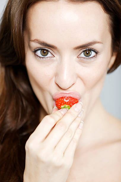 istock Woman biting into a strawberry 536816411