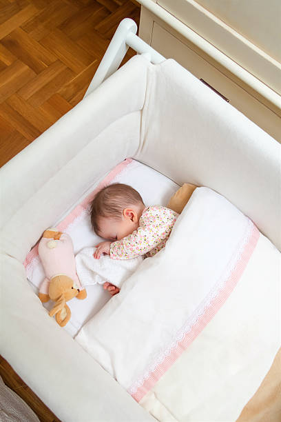 istock Baby girl sleeping in a cot with pacifier and toy 536831415