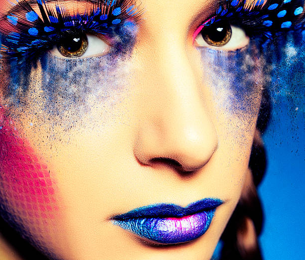 woman portrait with blue electric face paint posing.