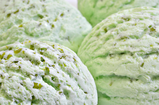 four scoops of green ice cream, pistachio, woodruff, peppermint or kiwi flavor, close up,  horizontal, full frame