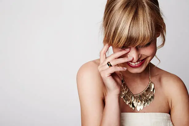 Beautiful blond laughing with gold necklace, close up
