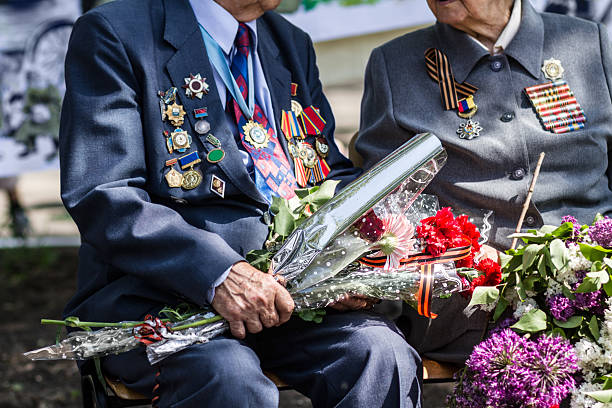 Cropped image of two war veterans holding flowers at a funeralhttp://195.154.178.81/DATA/istock_collage/376560/shoots/781192.jpg
