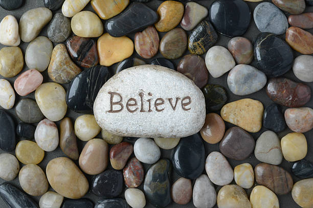 istock Flush Pebble Stone and River Background with word Believe 536853579