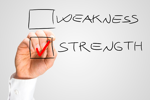 Hand Putting Red Check in Box Next to the Word Strength and Not Next to the Word Weakness.