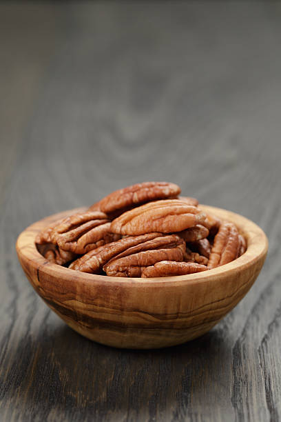 istock dried pecan nuts in olive bowl on wood table 536855789