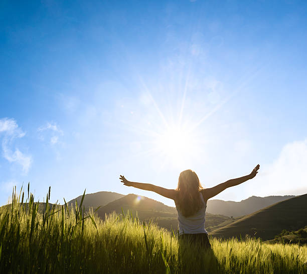 istock woman facing the sun with hands outstratched 536856341
