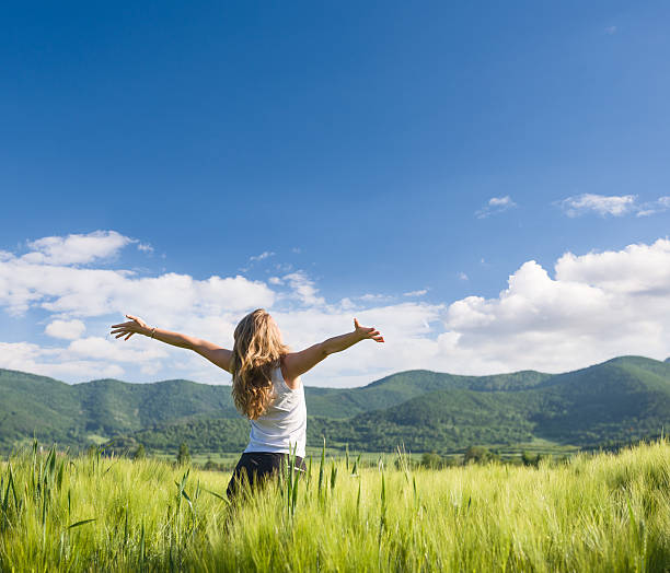 istock happy woman with hands outstretched in wheat field 536856343