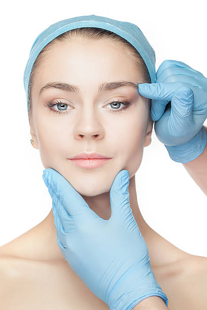 istock Plastic surgery concept. Doctor hands in gloves touching woman face 536870862