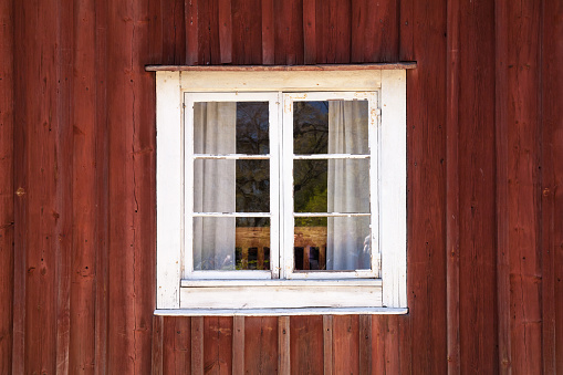 Old wooden wall with window in white frame