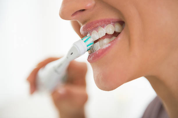 primer plano de mujer joven de lavarse los dientes. - colmillo fotografías e imágenes de stock