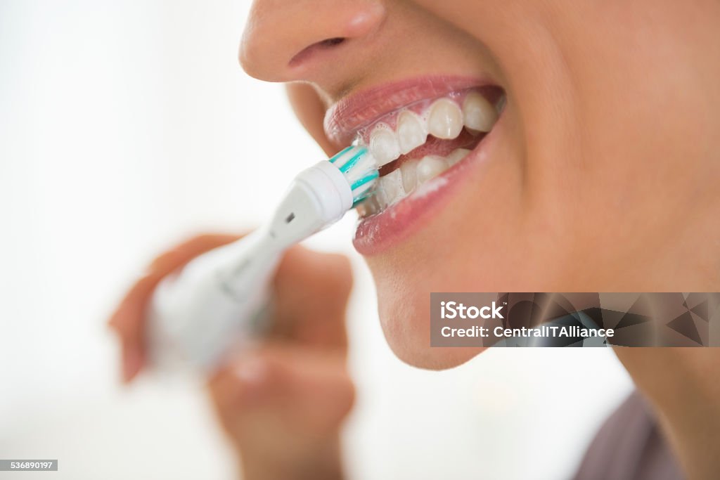 closeup on young woman brushing teeth Closeup on young woman brushing teeth Brushing Teeth Stock Photo