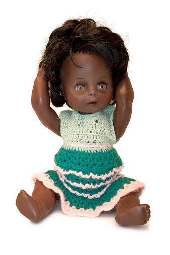 Vintage doll in a luxurious green dress with fur on a white background.