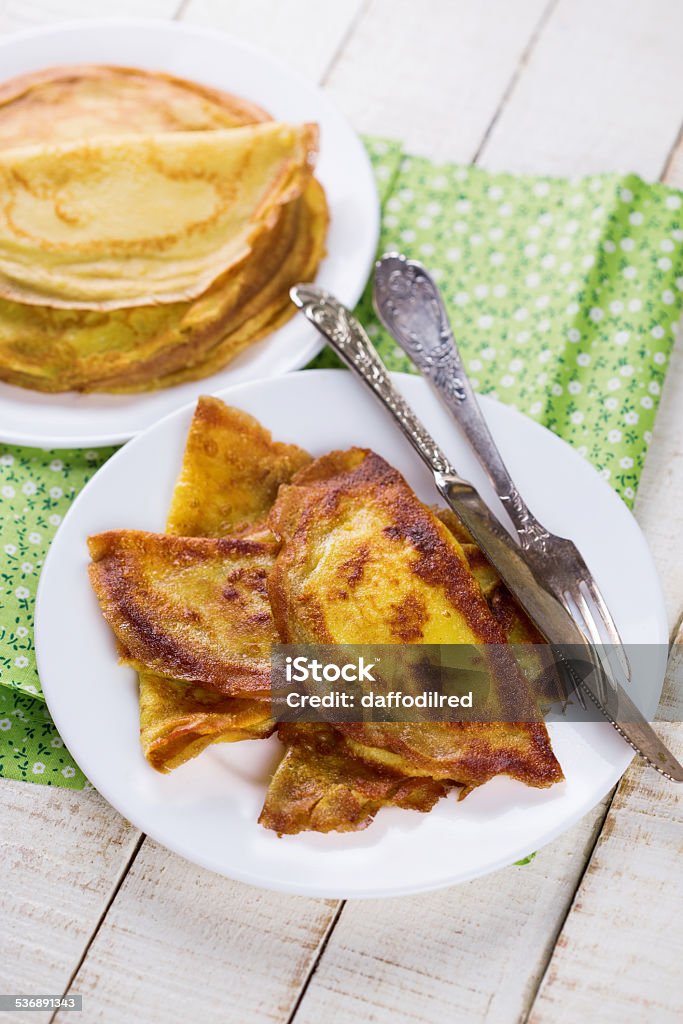 Pancakes or crepes with cheese Pancakes or crepes with cheese on plate on white wooden background. Selective focus. 2015 Stock Photo