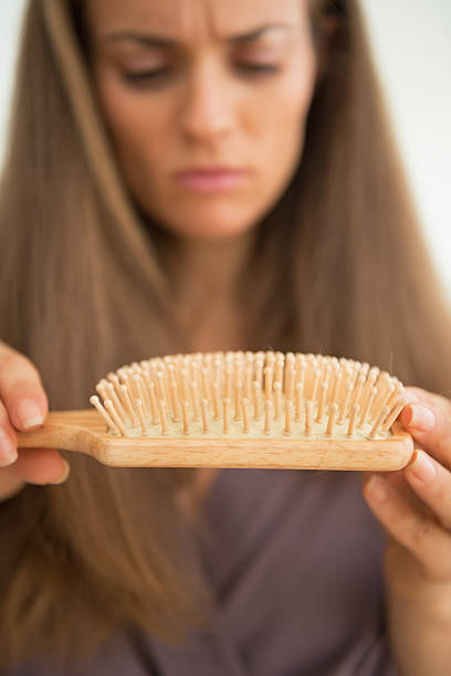 istock Concerned young woman looking on hair comb. Closeup 536891977