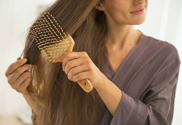 istock closeup on young woman combing hair 536892061