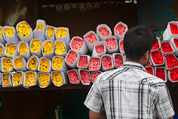 New Delhi, India - July 6, 2013.  An Indian man shops for roses at the wholesale flower market.