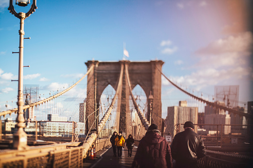New York City, NY, USA - January 30, 2015: Tourists and locals walk across the Brooklyn bridge. 