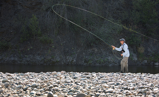 A man fly fishing on a western U.S. river.