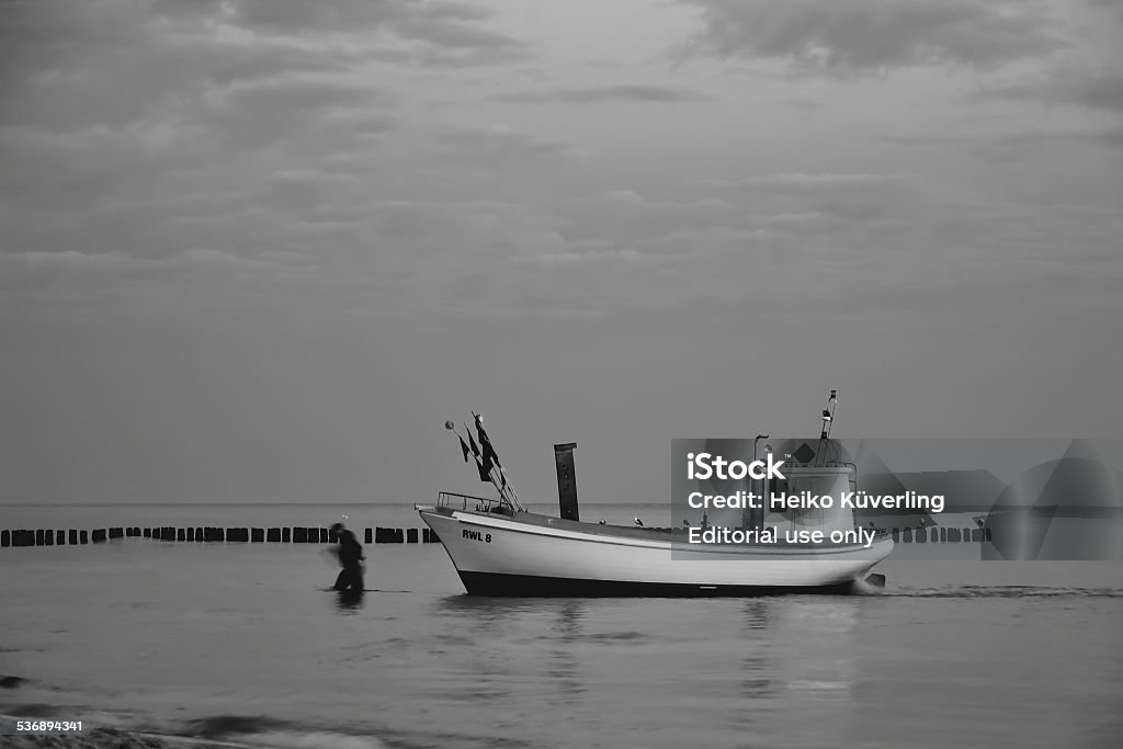 on the beach Rewal, Poland - August 29, 2012: A fisherman with his boat on the beach of the Baltic coast in the small town of Rewal 2015 Stock Photo