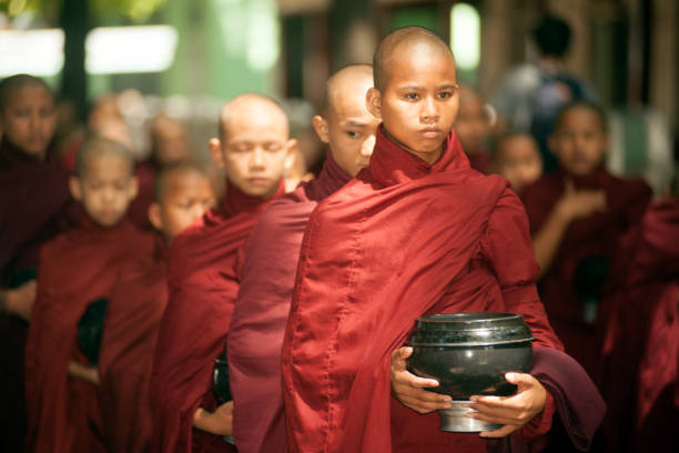 Novice Buddhist monk sitting & resting inside the temple