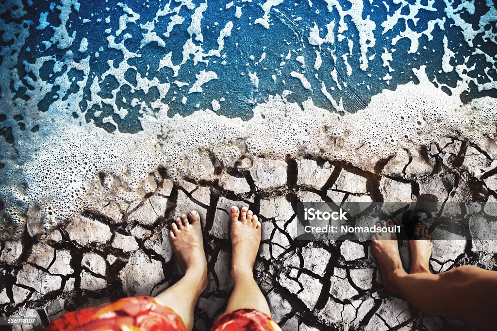 Feet standing on the beach Male and female feet are standing on the dry land on coast 2015 Stock Photo