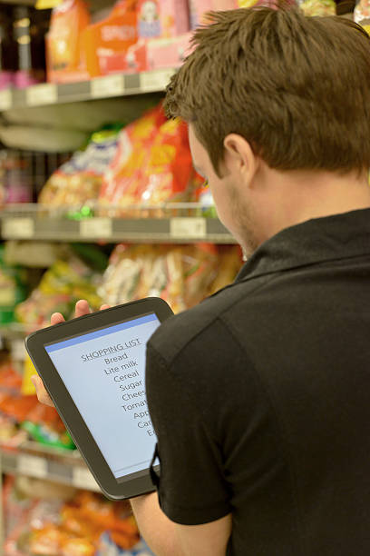 istock One young man shopping in supermarket using a computer tablet 536921097