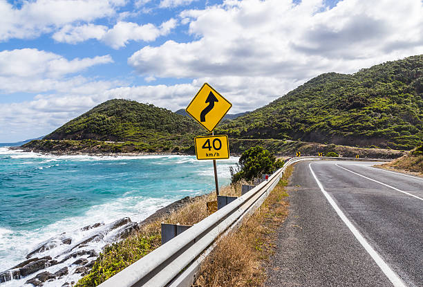 The yellow signs on the great ocean road The yellow bend and 40 km h speed limit signs on the great ocean road in Victoria,Australia speed limit sign australia stock pictures, royalty-free photos & images