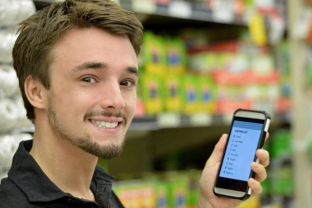 istock One young man shopping in supermarket using a cell phone 536921313