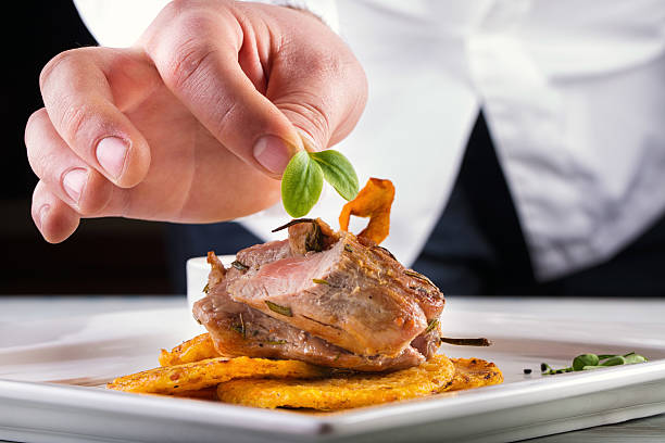 Chef in hotel or restaurant kitchen cooking, only hands.