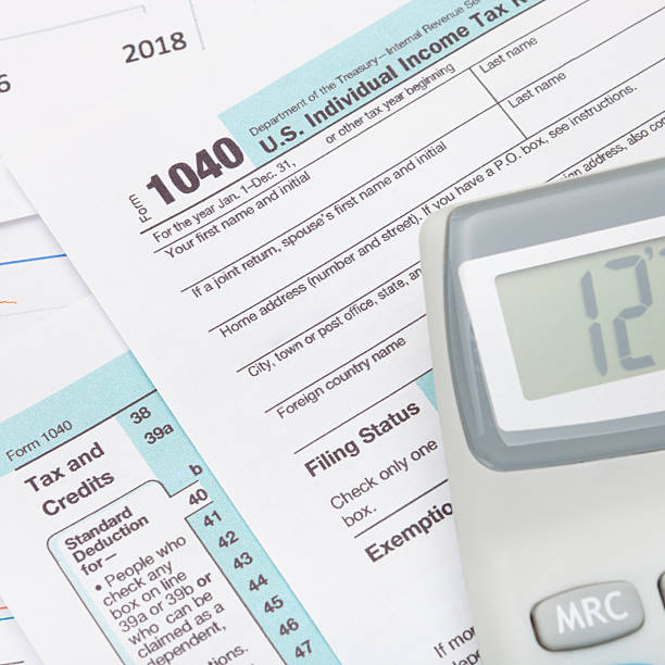 istock Calculator over US 1040 Tax Form - studio shot 536924595