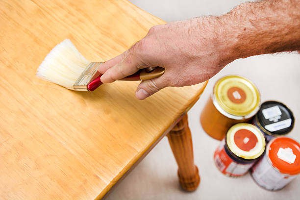 istock Man varnishing a chair with paintbrush 536950067