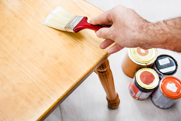 istock Man varnishing a chair with paintbrush 536950071