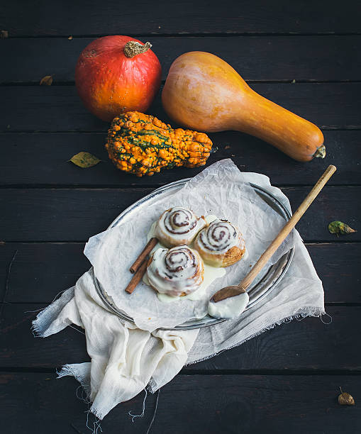 istock Cinnamon pumpkin buns with creamy cheese icing and ripe pumpkins 536950265