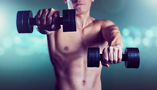 homem exercícios com halteres em fundo azul brilho - human muscle flash imagens e fotografias de stock