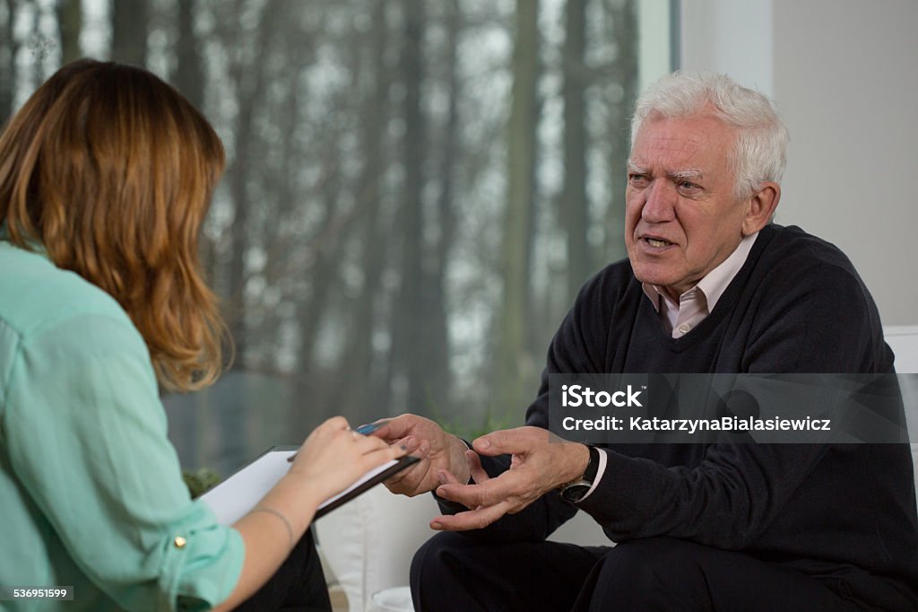 Elderly patient talking with psychotherapist Elderly patient talking with psychotherapist about his troubles 2015 Stock Photo