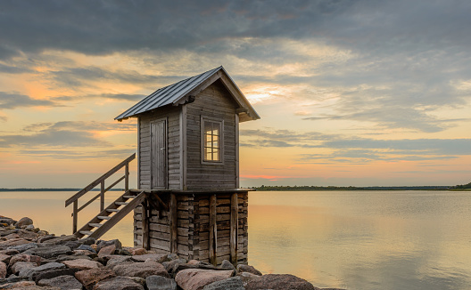 Small cabin by the sea with the sunset sky.